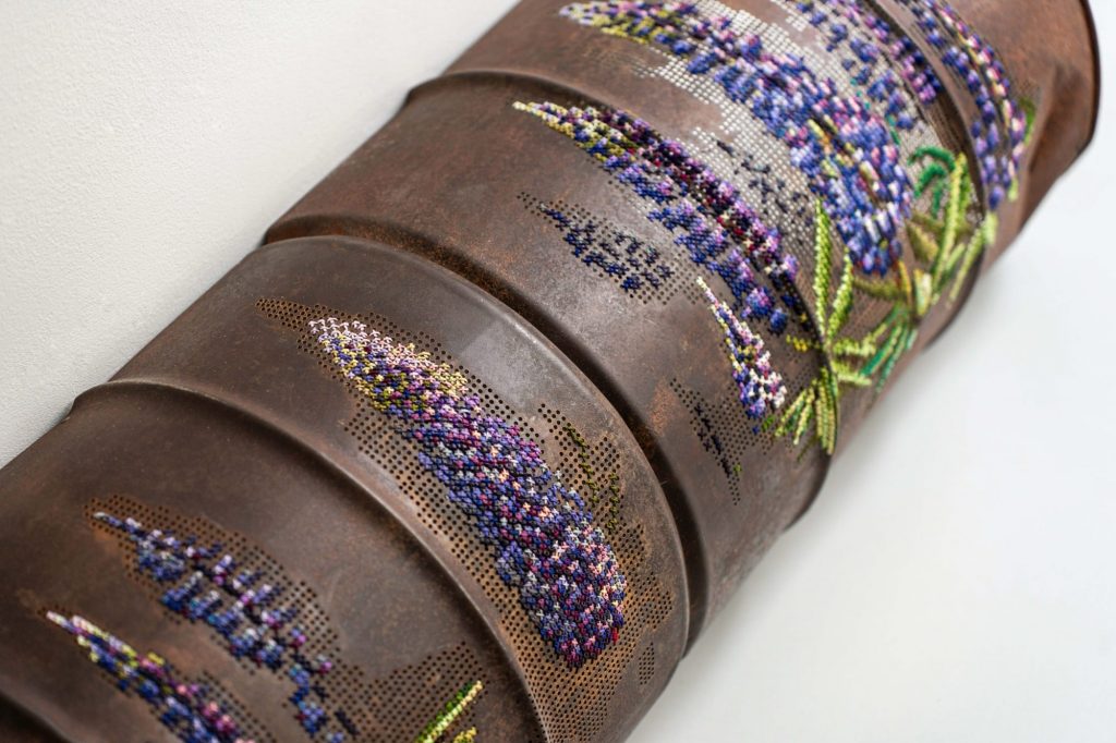 Flowers and Butterflies Stitch Messages of Hope into Crumpled Metal and Corroded Barrels